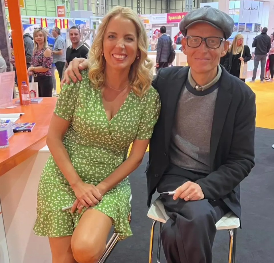 a woman in a green dress sits next to a man in glasses