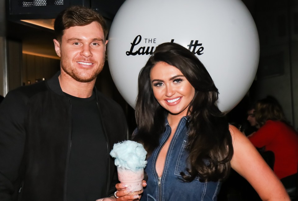 a man and a woman standing in front of a sign that says the laurette