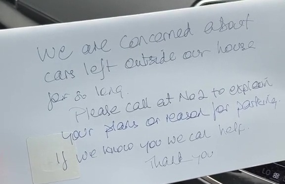 a person is holding a piece of paper that says " we are concerned about cars left outside our house for so long "