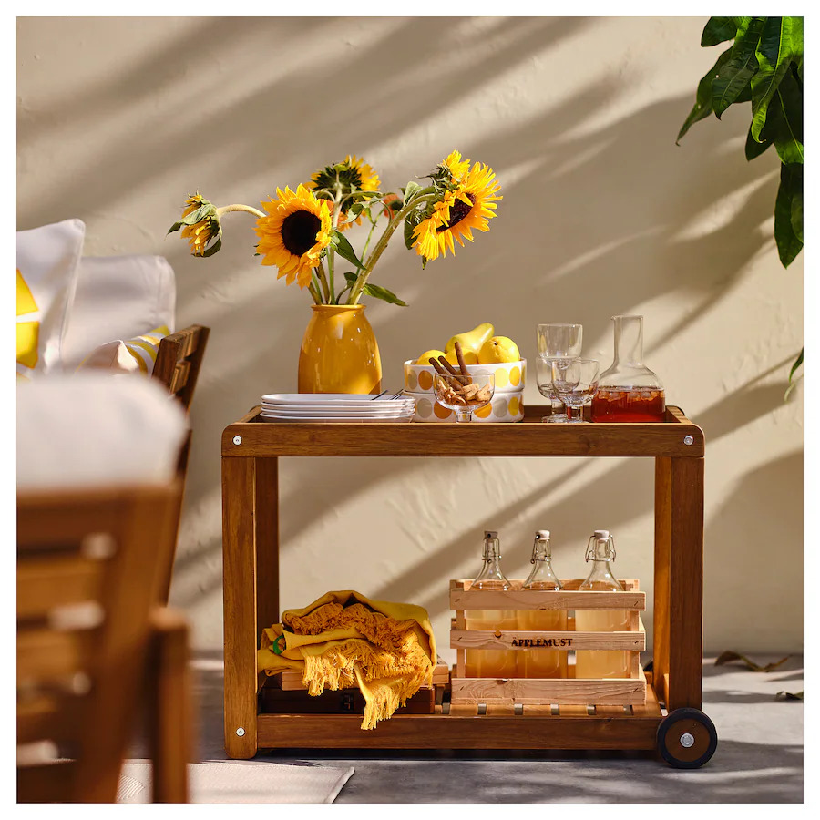 a wooden cart with a vase of sunflowers on top