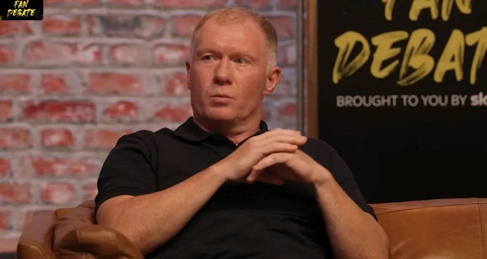 a man sits in front of a sign that says fan debate