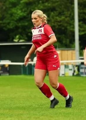 a woman in a red and white soccer uniform is running on a field .