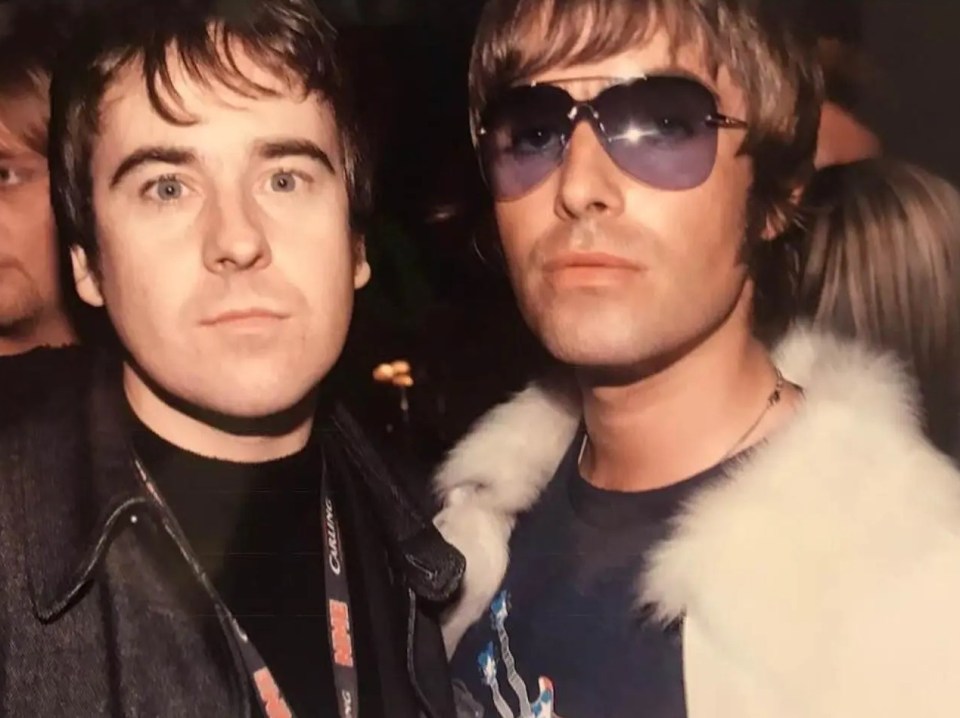 a man wearing sunglasses stands next to another man wearing a lanyard that says cbs