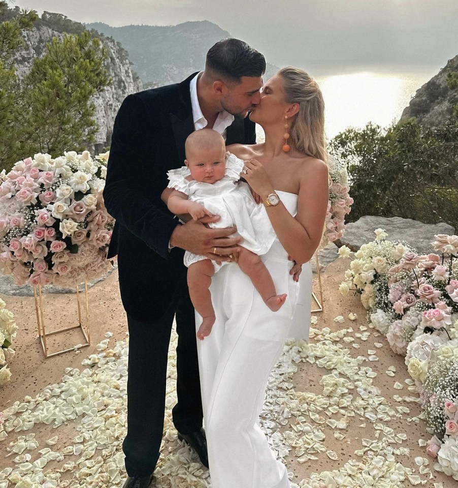 a man and woman kiss while holding a baby