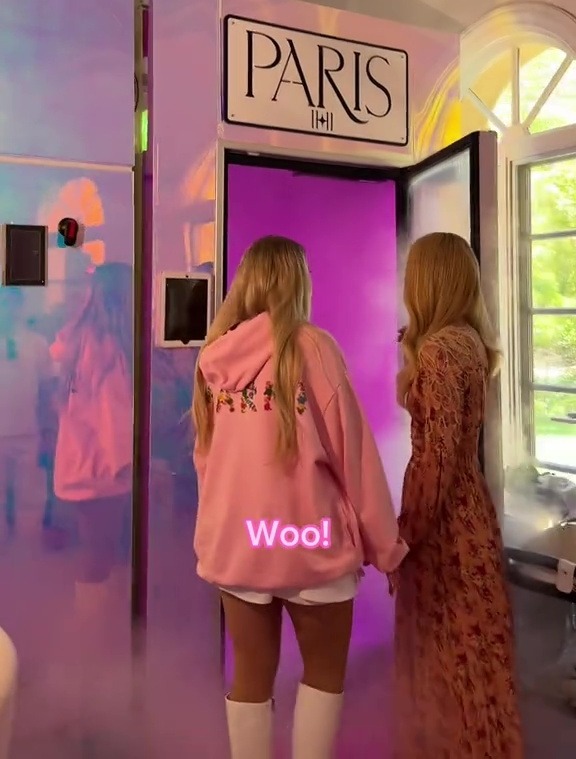 two women standing in front of a paris sign