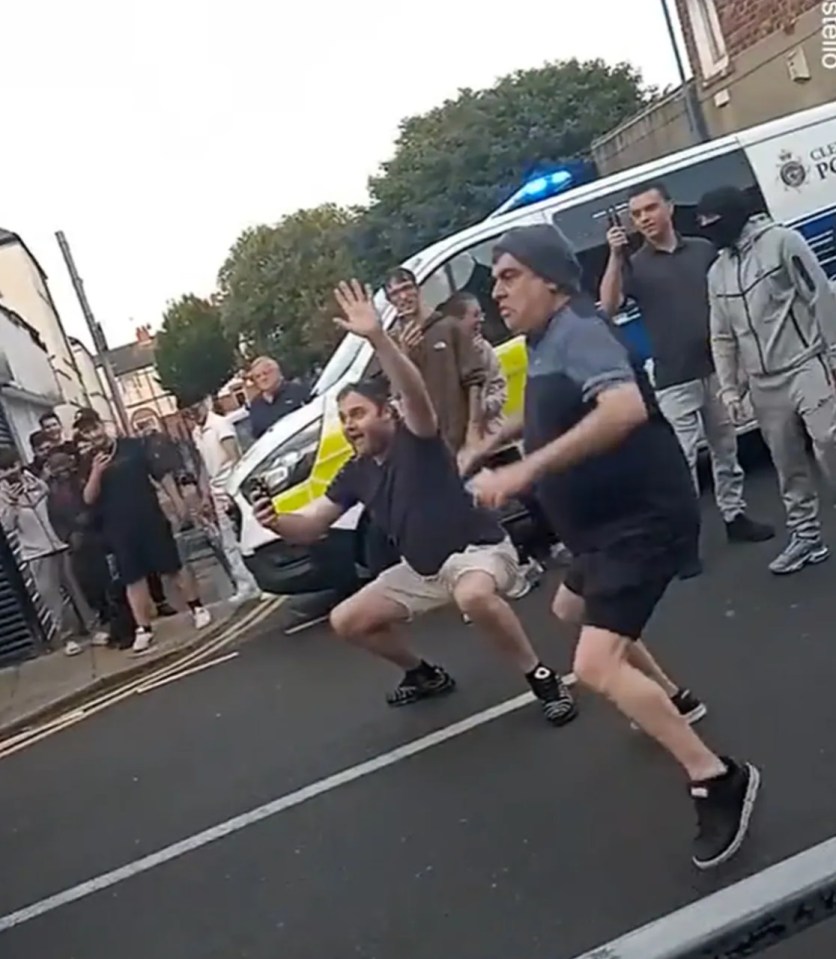 a group of men are running down a street in front of a police van