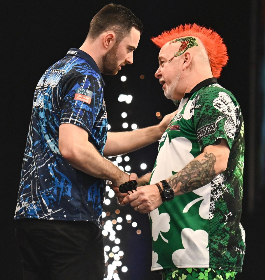 two men shaking hands with one wearing a green shirt with shamrocks on it