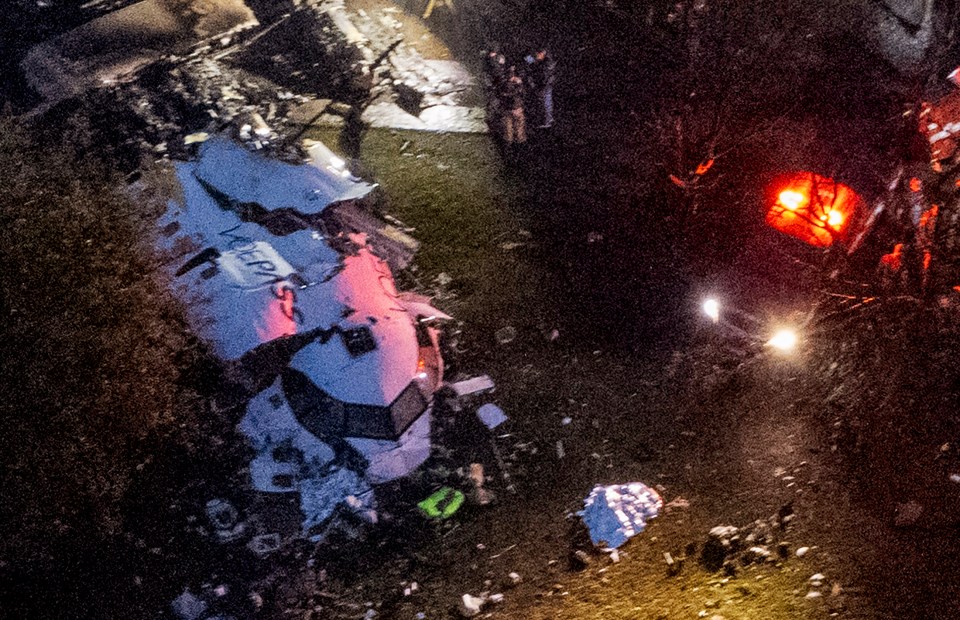 an aerial view of a plane wreckage with smoke coming out of it