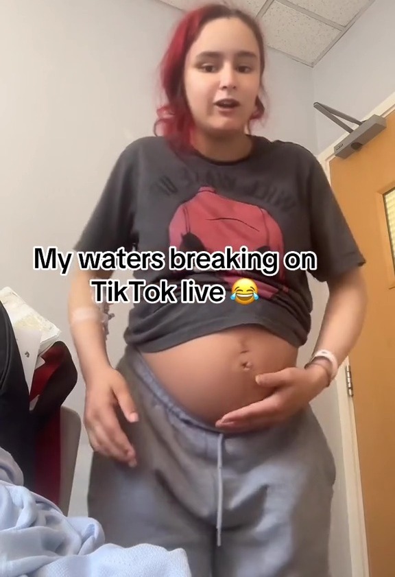 a pregnant woman is standing in a room with her hands on her belly and says " my waters breaking on tiktok live "