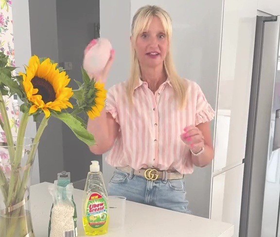 a woman in a pink and white striped shirt is holding a bottle of knorr dish soap