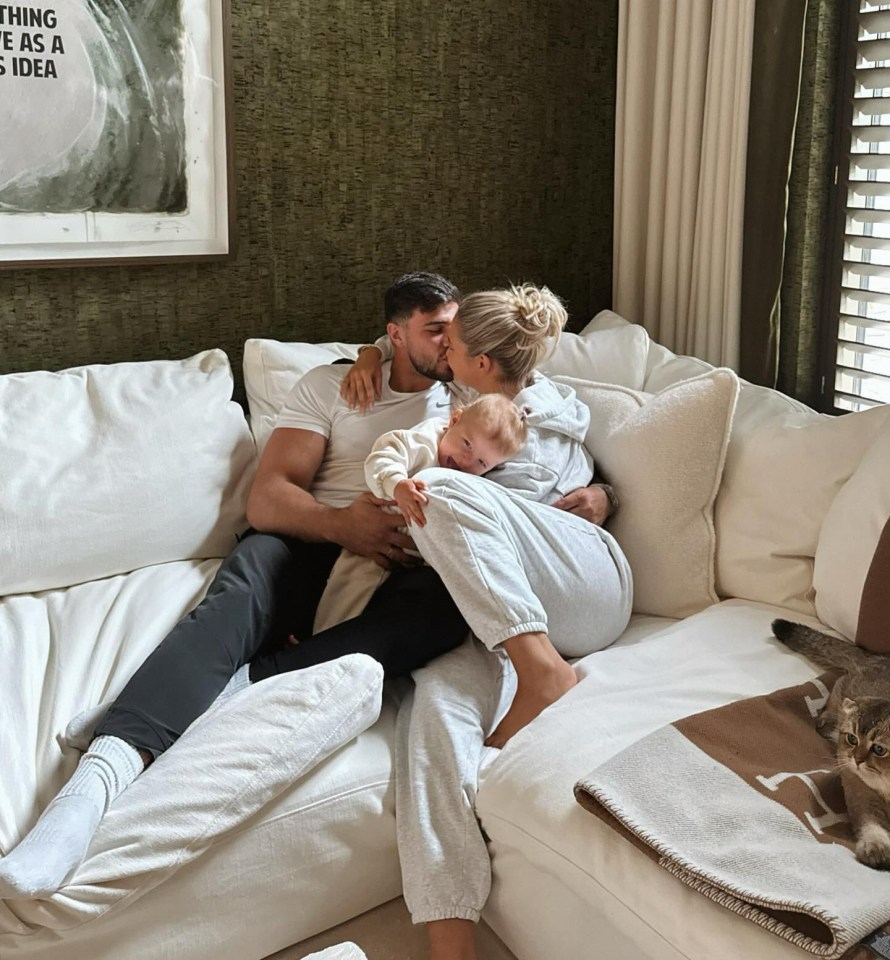 a man kisses a woman on the cheek while holding a baby