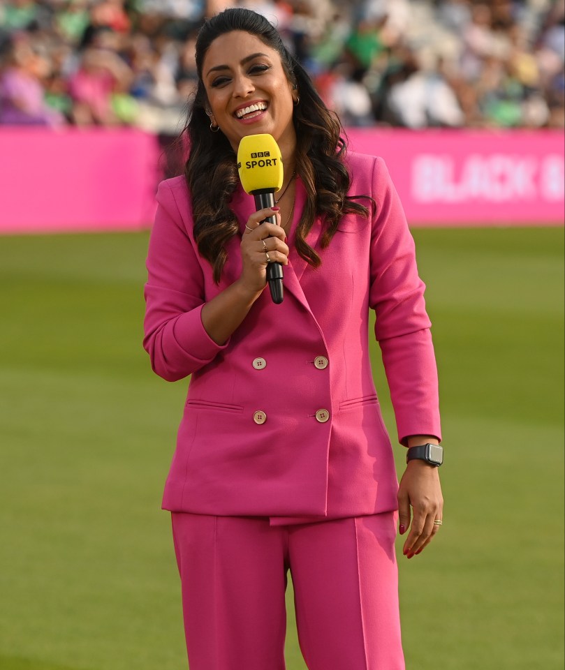 a woman in a pink suit is holding a yellow bbc sport microphone