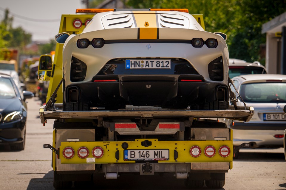 A Ferrari 812 Competizione is taken away by authorities after it was removed from Andrew Tate’s residence