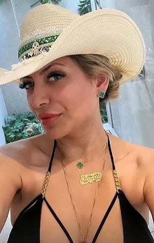 a woman in a bikini and a cowboy hat is taking a selfie .