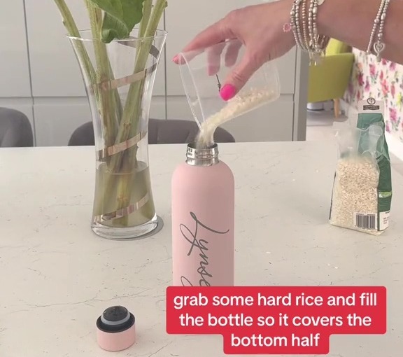 a woman is pouring rice into a pink bottle that says happiness