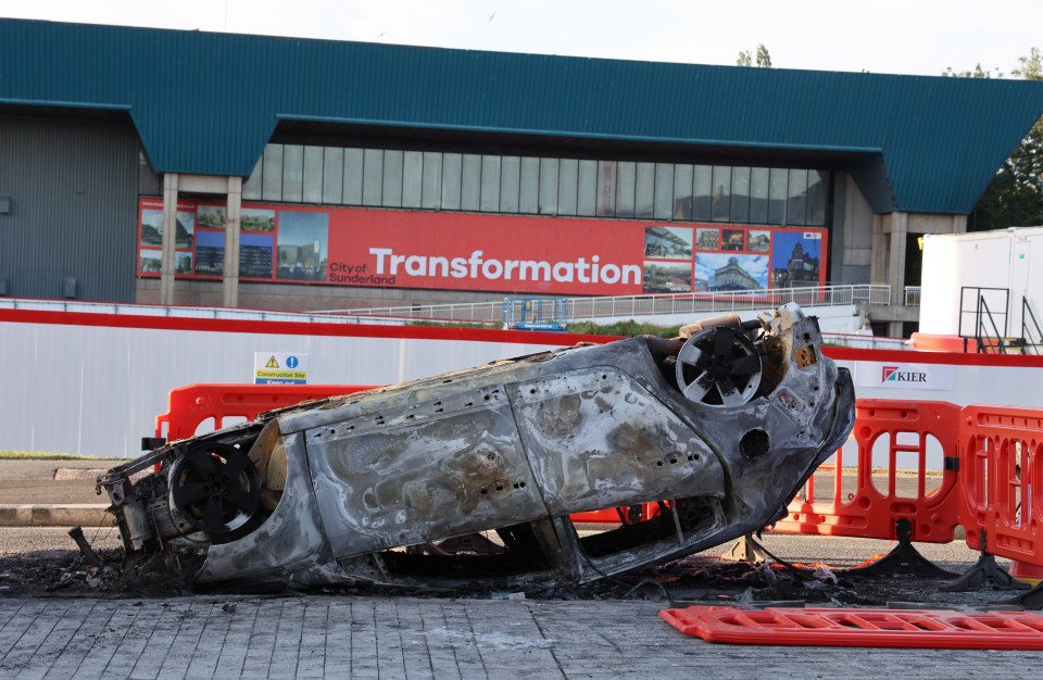 The burnt wreckage of a car this morning after a night of violent protests by right wing mobs