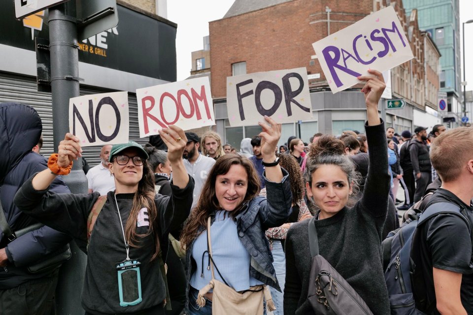 a group of people holding up signs that say no room for racism