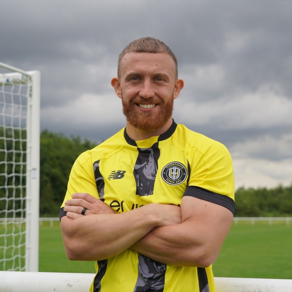 a man with a beard wears a yellow jersey with the letter b on it