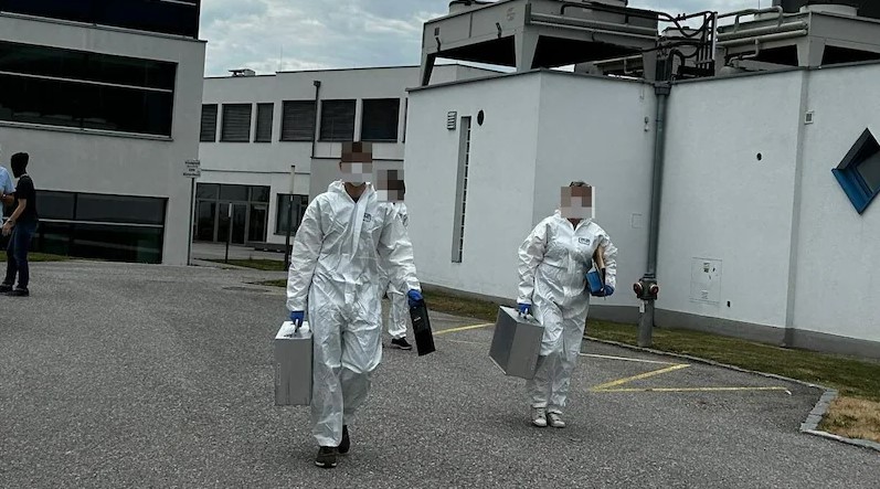 A picture showing cops in hazmat suits during one of the raids that led to the arrests