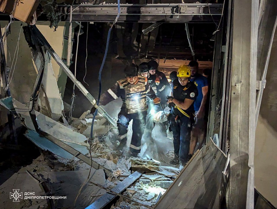 Ukrainian rescuers working at the site of a rocket strike