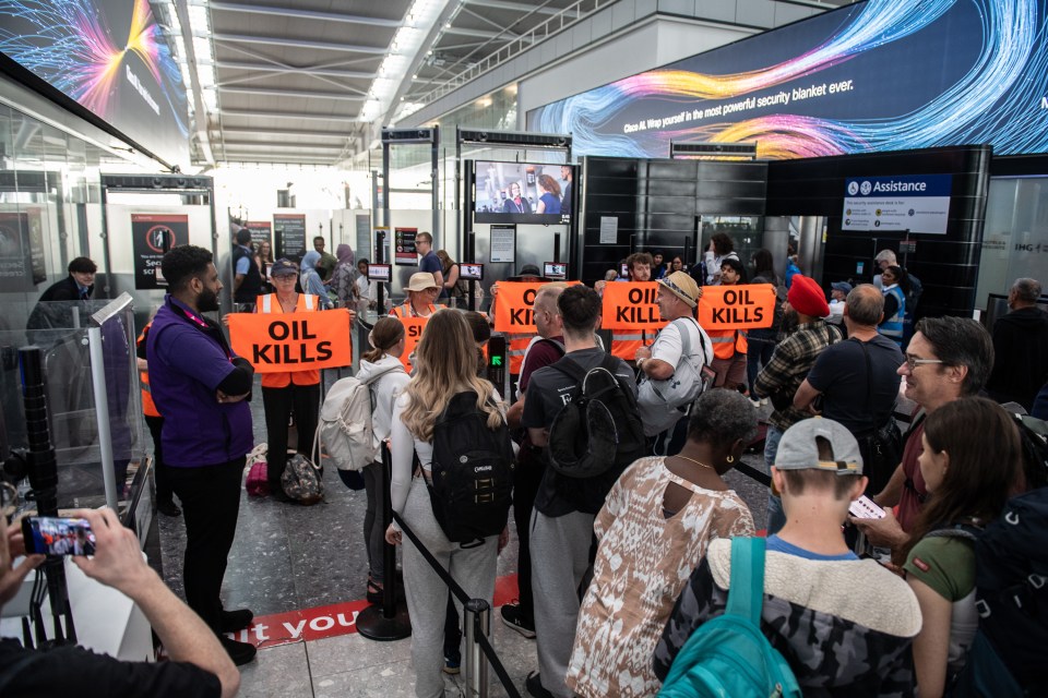 a group of people holding orange signs that say " oil kills "