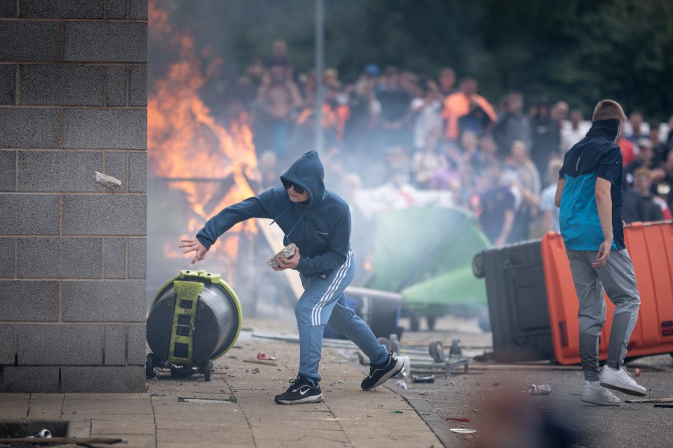 ROTHERHAM, ENGLAND - AUGUST 4: Riot police officers push back anti-migration protesters outside the Holiday Inn Express Hotel which is housing asylum seekers on August 4, 2024 in Rotherham, United Kingdom. Yesterday saw widespread violence as Far-right agitators in Liverpool and Manchester rioted and looted shops. Police were attacked and injured and dozens of arrests were made. (Photo by Christopher Furlong/Getty Images)