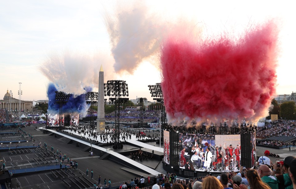 PARIS, FRANCE - AUGUST 28: A general view as smoke is released in the colours of the French flag whilst dancers perform during the discord act at the opening ceremony of the Paris 2024 Summer Paralympic Games at Place de la Concorde on August 28, 2024 in Paris, France. (Photo by Ezra Shaw/Getty Images)