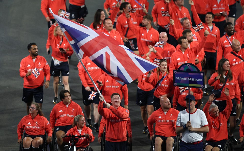 PARIS, FRANCE - AUGUST 28: Terry Bywater and Lucy Shuker, Flag Bearers of Team Great Britain, hold their national flag as they parade during the opening ceremony of the Paris 2024 Summer Paralympic Games at Place de la Concorde on August 28, 2024 in Paris, France. (Photo by Elsa/Getty Images)