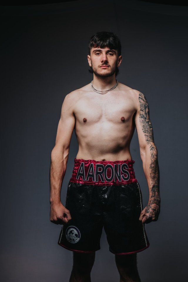 a shirtless boxer with the name aarons on his shorts