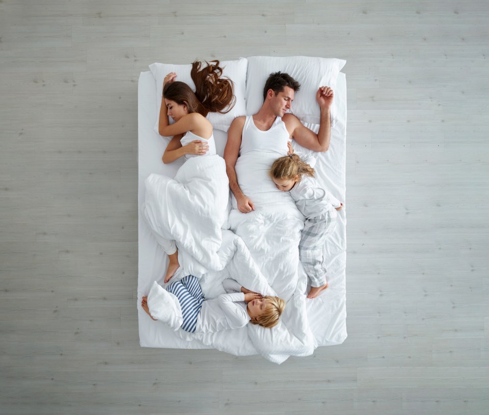 Family sleeping in bed.