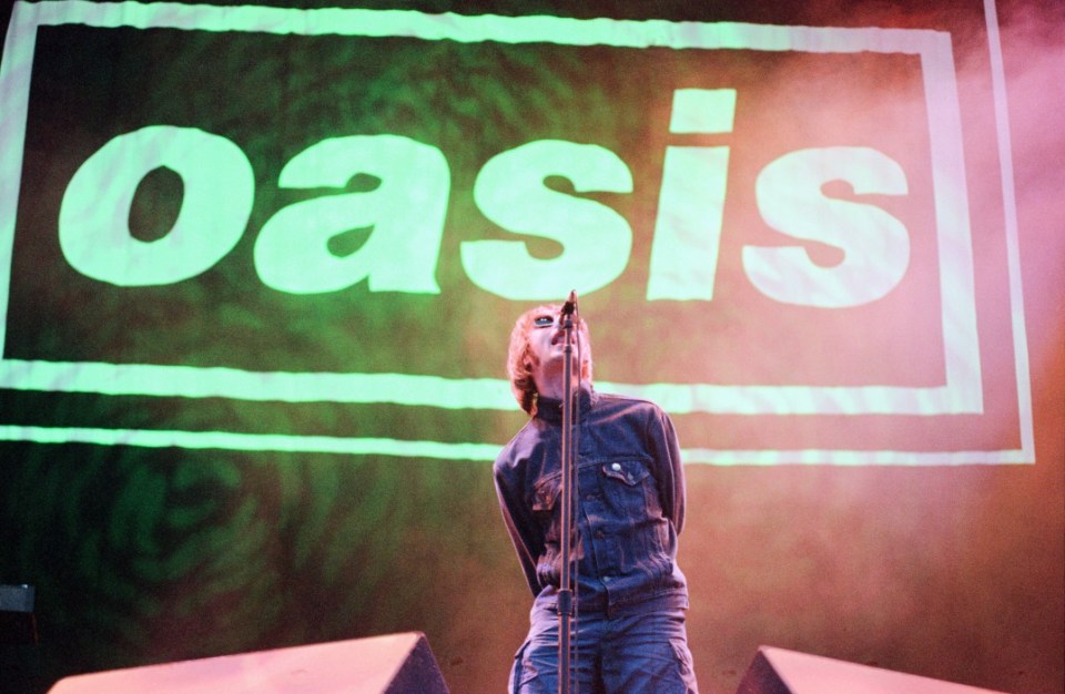  Liam Gallagher performing on stage with Oasis in 1996