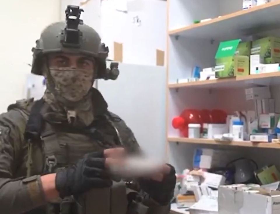 a man wearing a helmet and mask is standing in front of a shelf full of pills