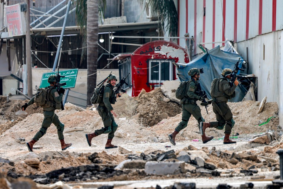 Troops run across the rubble amid the West Bank fighting