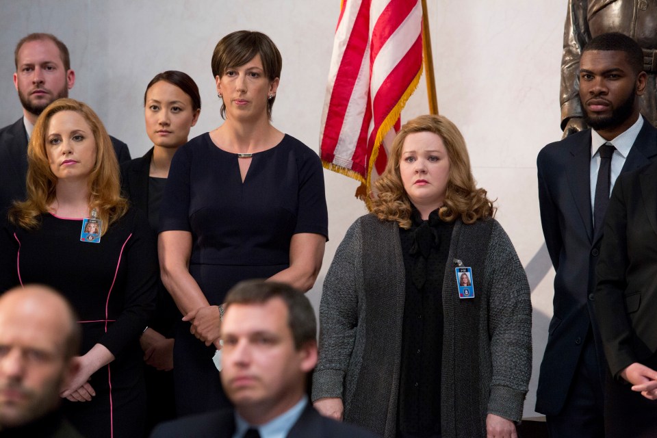 a group of people standing in front of an american flag