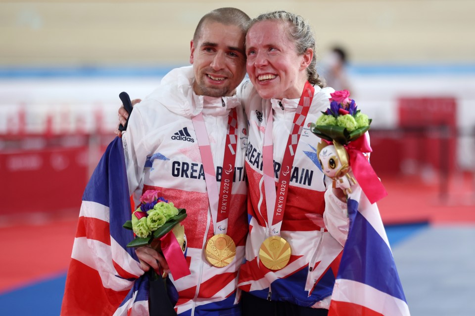 a man and a woman are posing for a picture with medals around their necks that say great britain