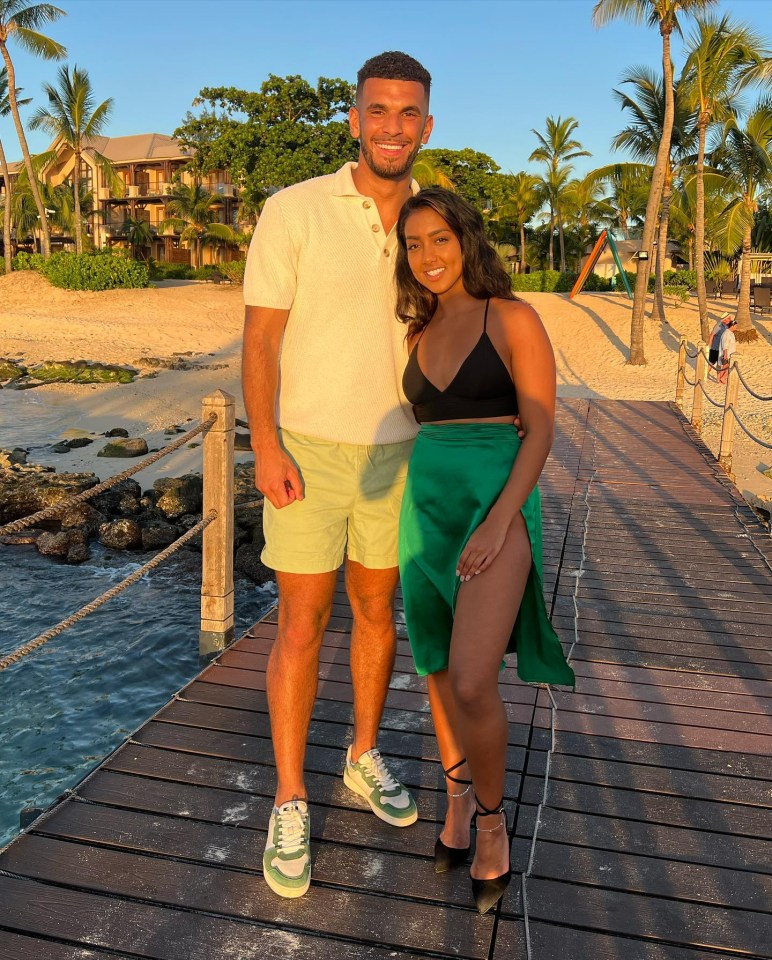 a man and a woman are posing for a picture on a dock