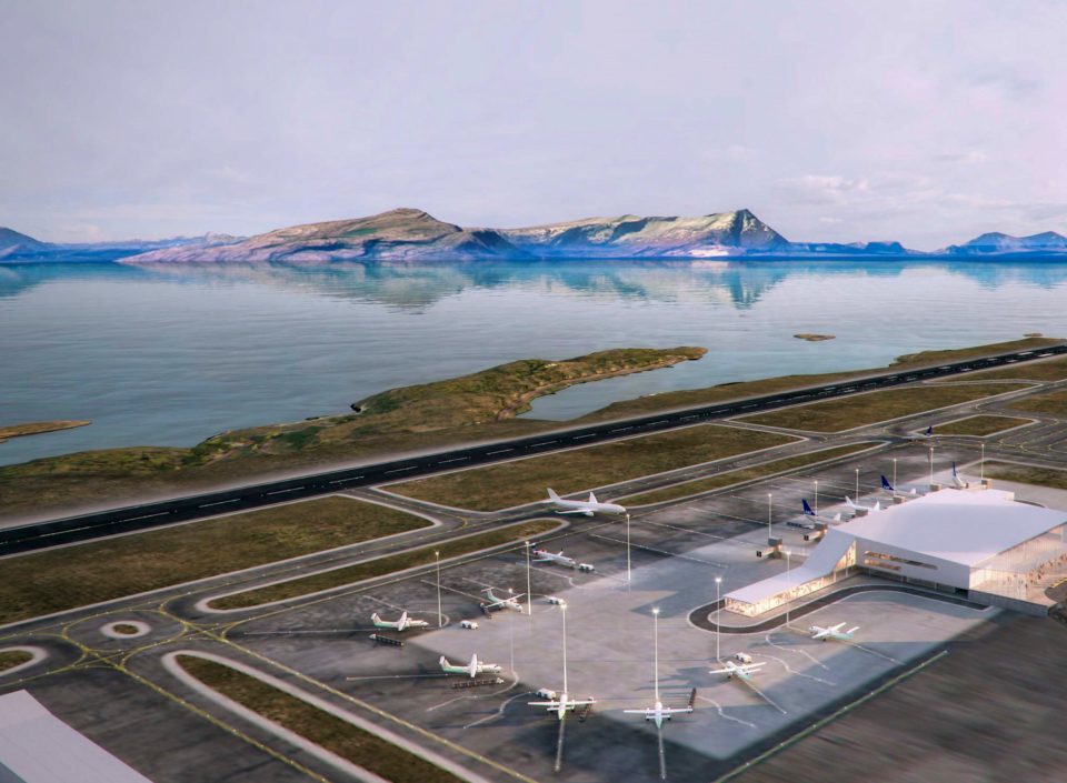 an aerial view of an airport with mountains in the background