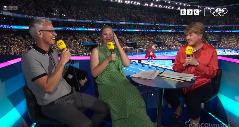 three people sitting at a table with microphones in front of a bbc logo