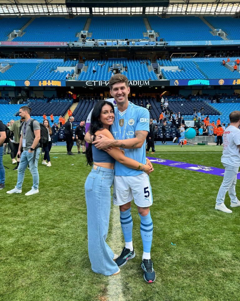 a man in a number 5 jersey stands on a field with a woman