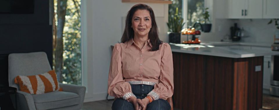 a woman in a pink shirt is sitting in a chair