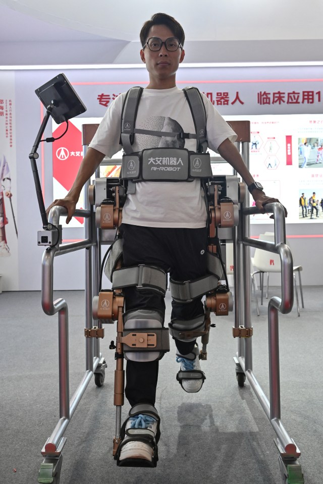 A man steps out in AI walker gear at the World Robot Conference in Beijing, China