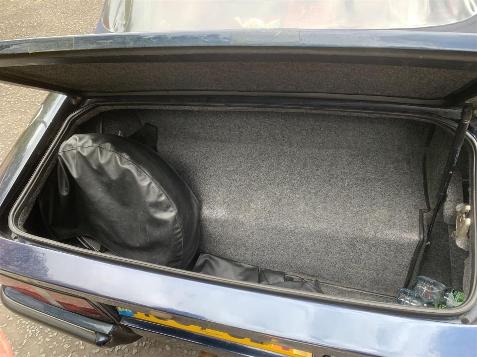 the trunk of a car has a spare tire in it