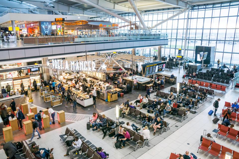 a busy airport with a sign that says pret a manger