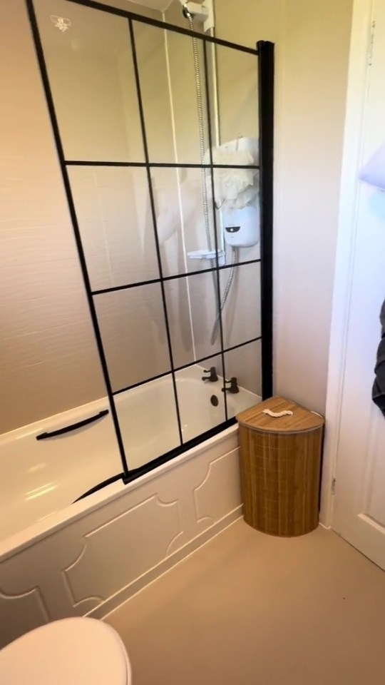 a bathroom with a bathtub and a laundry basket