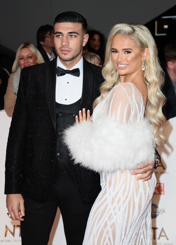 a man in a tuxedo stands next to a woman in a white dress