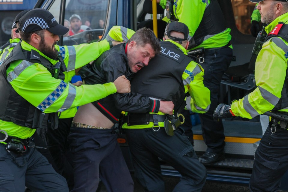 Cops detain a person at a protest in Blackpool