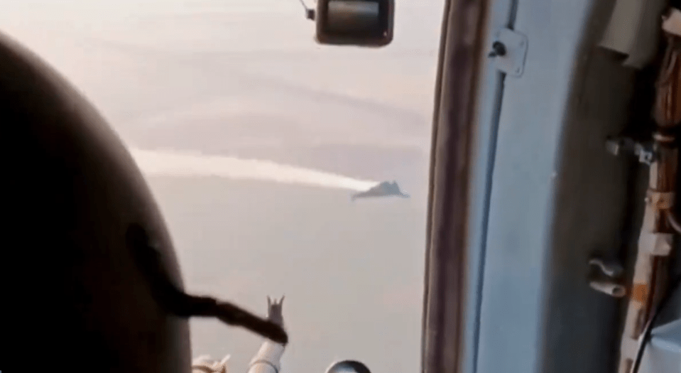 a plane is flying over a body of water with a mountain in the distance