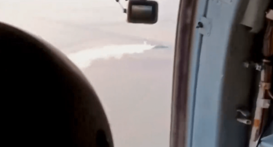 a plane is flying over a large body of water