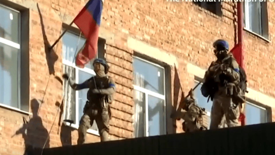 soldiers holding flags in front of a building that says the national