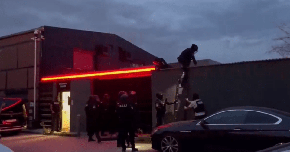 Cops are seen using a ladder to climb onto the roof